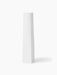 A tall, slender, white sculptural Ignus Flameless Candle made from matte bone china, shown at an angle on a white background.