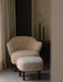 Ingeborg Lounge Chair and ottoman in Moonlight sheepskin, styled in a minimalist room with Stance Vases and a beige curtain.