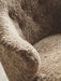 Close-up of the Ingeborg Lounge Chair's armrest and seat, showcasing the plush, curly texture of the brown sheepskin.