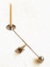 Audo Interconnect Candle Holder, Small, in polished steel, a sculptural piece balancing a beige candle on a cream surface.