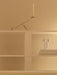 Silver Interconnect Candle Holder and portable Column Table Lamp on minimalist white shelves against a beige wall.