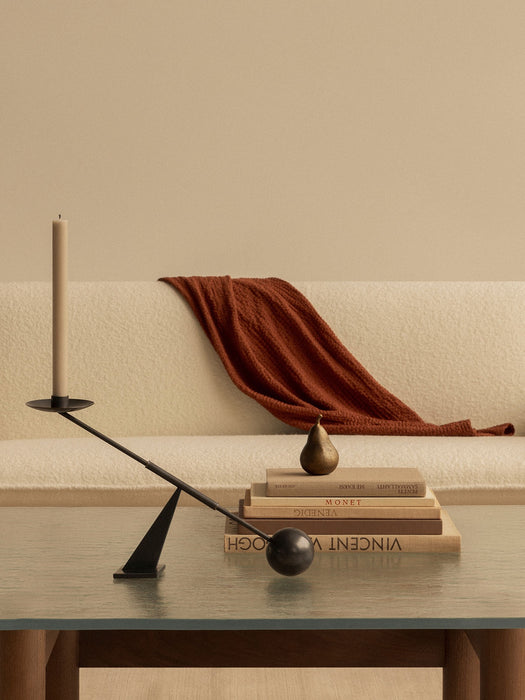 The black Interconnect Candle Holder on a glass-topped Brasilia Lounge Table, with the cream Brasilia Sofa in the background.