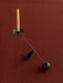 Audo's black metal Interconnect Candle Holder Small with a cream taper candle, shot from above on a rich, textured red cloth.