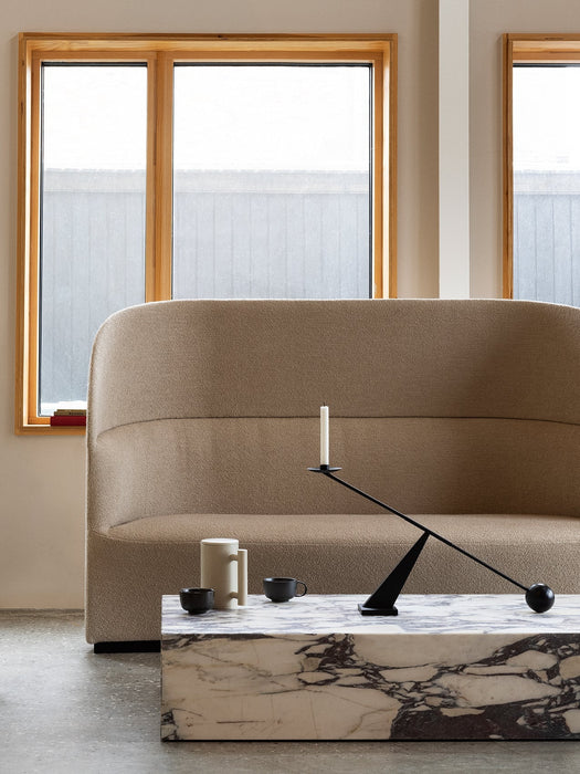 The beige Tearoom High Back Sofa is styled with a marble Plinth coffee table and a black Grand Interconnect Candle Holder.