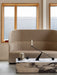 The beige Tearoom High Back Sofa is styled with a marble Plinth coffee table and a black Grand Interconnect Candle Holder.