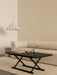 The black Jäger Lounge Table in a neutral living room with an Eave Modular Sofa and a white Dancing Pendant lamp overhead.