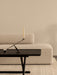 A black Jäger Lounge Table with an Interconnect Candle Holder, placed in front of a beige Eave Modular Sofa in a calm room.