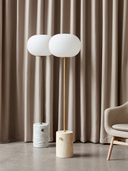 The JWDA Floor Lamp shown in two versions: white marble with a bronzed stem and travertine with a brushed brass stem.