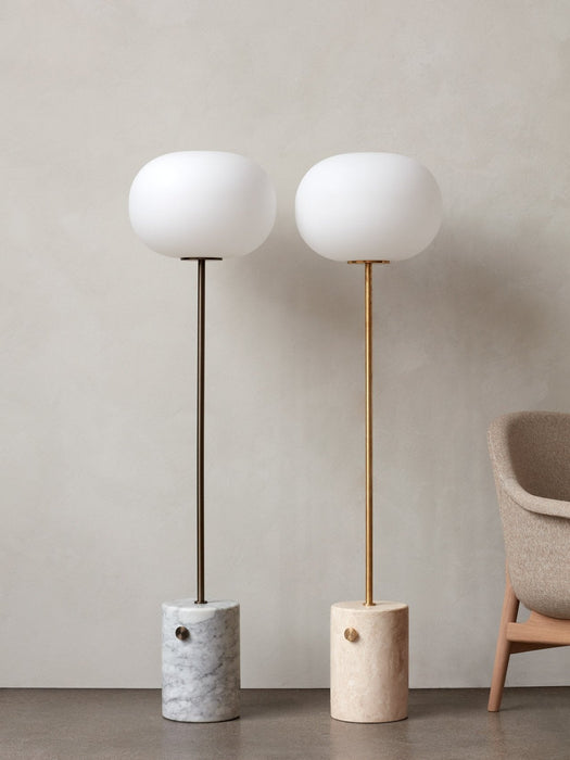 The JWDA Floor Lamp in two variations: white marble with a bronzed brass stem and travertine with a brushed brass stem.