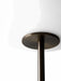 A close-up shot of the JWDA Floor Lamp showing the point where the bronzed brass stem connects to the white opal glass shade.