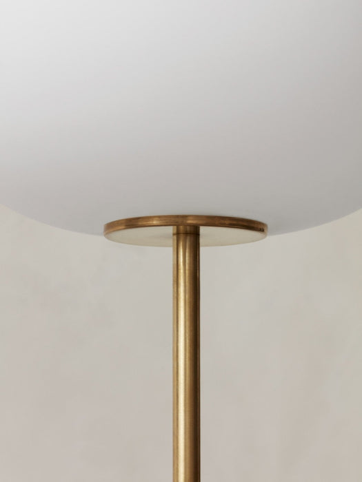 A detailed close-up of the JWDA Floor Lamp, showing the smooth white opal glass shade meeting the slender brushed brass stem.