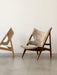 Two Knitting Lounge Chairs in Sheepskin, one dark wood frame, one light wood frame, in a minimalist interior.