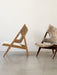 Side profile of the Knitting Lounge Chair with a natural oak frame and off-white Sheepskin in a bright, modern room.