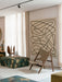 The Knitting Lounge Chair in natural oak and light leather, pictured in a bright, modern living room with abstract wall art.
