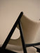 Close-up from behind the Knitting Lounge Chair, Black Oak, highlighting its black frame and textured ivory upholstery.