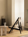 Side view of the Knitting Lounge Chair in black oak with the Androgyne Side Table, Column Table Lamp, and Plinth Pedestal.