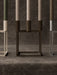 A close-up of ivory, brown, and silver Kubus 4 candle holders with olive and beige candles on a dark, textured surface.