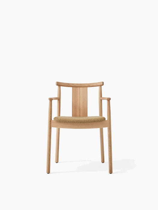 Front view of the Merkur Dining Chair w/Armrests. The chair has a natural oak frame and a seat upholstered in beige Bouclé.