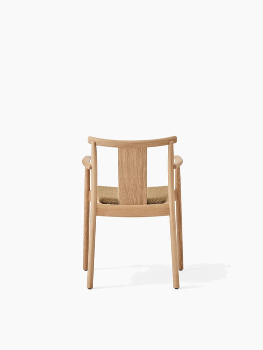 Back view of the Merkur Dining Chair with Armrests, showing its natural oak frame and Audo Bouclé 06 upholstered seat.