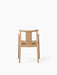 Back view of the Merkur Dining Chair with Armrests, showing its natural oak frame and Audo Bouclé 06 upholstered seat.
