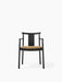 Front view of the Merkur Dining Chair with Armrests. It has a black oak frame and a textured beige Audo Bouclé seat cushion.
