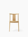 Front view of the Merkur Dining Chair in natural oak, showing its minimalist design with a curved backrest and four legs.