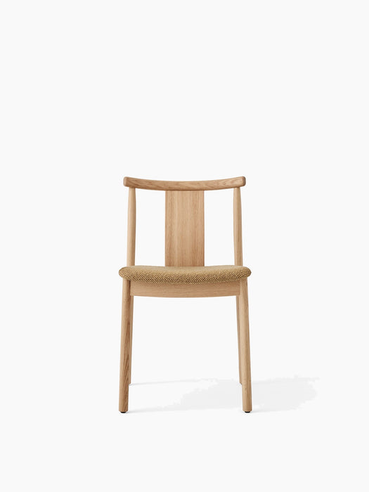 Front view of the Merkur Dining Chair. The chair has a natural oak frame with a curved back and a light brown bouclé seat.