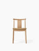 Front view of the Merkur Dining Chair. The chair has a natural oak frame with a curved back and a light brown bouclé seat.