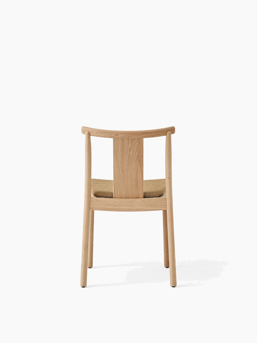 Back view of the Merkur Dining Chair in natural oak, featuring curved backrest and textured, beige bouclé upholstered seat.