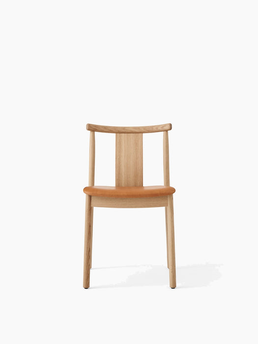 Front view of the Merkur Dining Chair, shown with a natural oak frame and an upholstered seat in warm tan Dakar leather.