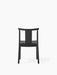 Back view of the Merkur Dining Chair in black oak, with its minimalist frame, curved top rail, and central back slat.
