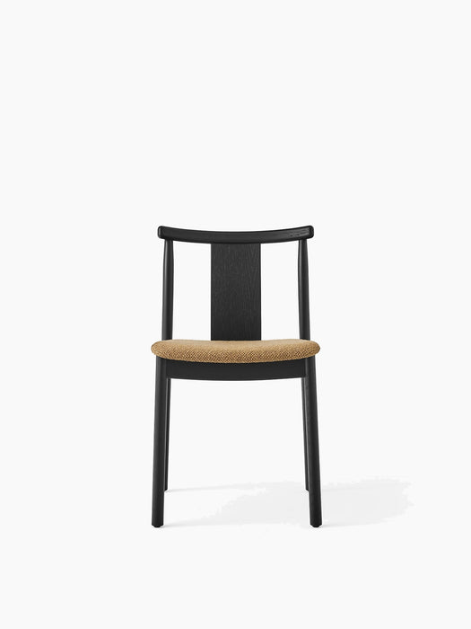 Front view of the Merkur Dining Chair in black oak. The seat is upholstered in a textured golden-brown bouclé fabric.
