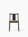 Front view of the Merkur Dining Chair in black oak. The seat is upholstered in a textured golden-brown bouclé fabric.