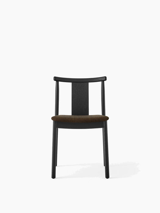 Front view of the Merkur Dining Chair, featuring a black oak frame with a curved backrest and a dark brown upholstered seat.
