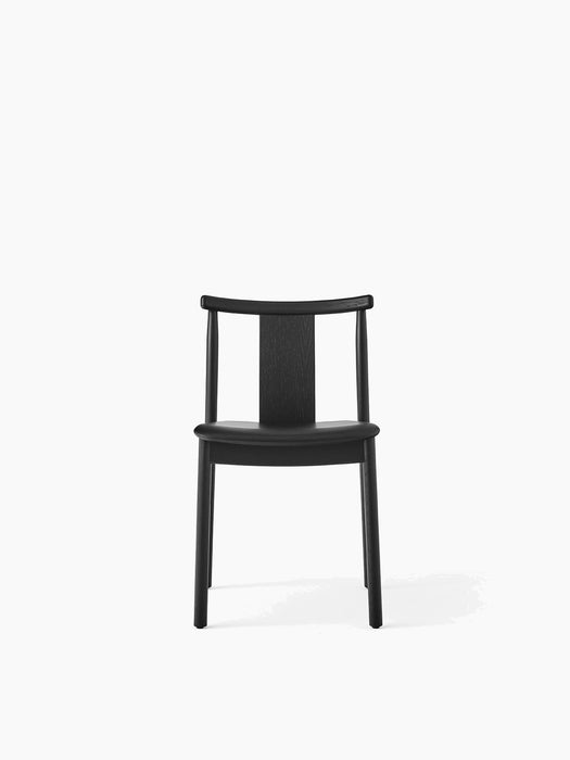 Front view of the Merkur Dining Chair in black oak, featuring a solid seat and a curved backrest, on a white background.