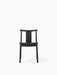 Front view of the Merkur Dining Chair in black oak, featuring a solid seat and a curved backrest, on a white background.