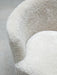 A close-up shot of the Mingle Sofa, highlighting the plush, textured off-white sheepskin covering the curved seat and back.
