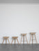 A row of four ML 42 stools in light oak, showcasing the different heights from stool to counter and bar stool versions.