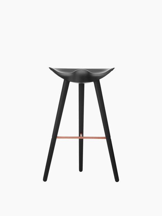 A front-on view of the ML 42 Bar Stool in black stained beech. The 3-legged stool has a moulded seat and a copper footrest.