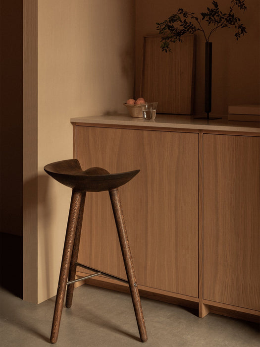 The dark wood ML 42 Counter Stool in a kitchen setting with a Stance Vase and Strandgade Drinking Glass on the counter.