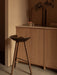 The dark wood ML 42 Counter Stool in a kitchen setting with a Stance Vase and Strandgade Drinking Glass on the counter.