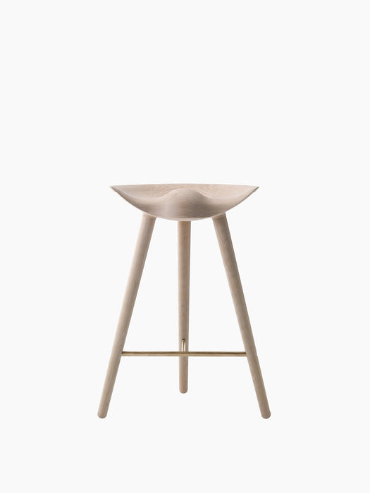 A front-on image of the ML 42 Counter Stool, crafted from light-coloured oak with a sculptural seat and a brass footrest.