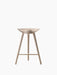 A front-on image of the ML 42 Counter Stool, crafted from light-coloured oak with a sculptural seat and a brass footrest.