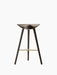 Front view of the ML 42 Counter Stool in dark smoked oak. The three-legged stool has a sculptural seat and a brass footrest.