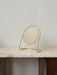 The Nimbus Table Mirror, featuring a circular mirror in a polished brass stand, rests on a veined marble tabletop.