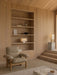 A wood-panelled room featuring a beige Brasilia Lounge Chair and built-in shelves, with a lit Nonna Table Lamp on display.