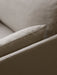 Close-up of a sofa's upholstery in a light brown, textured, woven fabric. The corner of a soft cushion is visible.