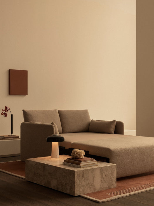 Beige Offset Sofa Bed on a Duomo Rug, partially extended, with a marble Plinth Low table and Reverse Lamp.