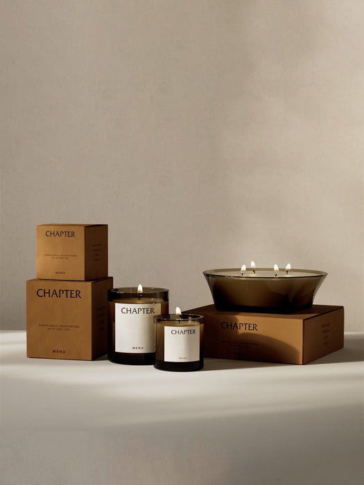 A collection of lit Olfacte Scented Candles from Audo CPH, including two glass jar candles and a large multi-wick bowl.
