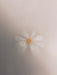 A dreamy, soft-focus shot of a single white and yellow flower, representing the Audo Olfacte Scented Candle En Passant.